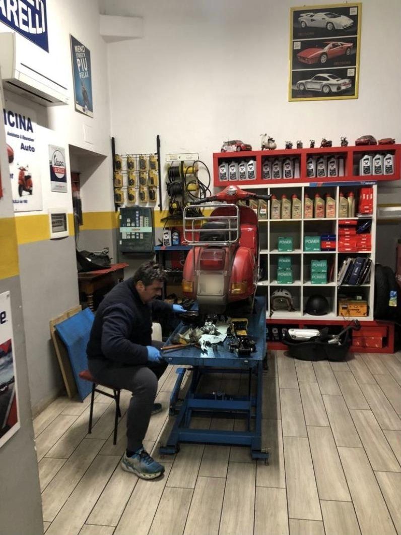 Al lavoro su una Vespa rossa sul ponte, nell'officina Fratelli Colella
